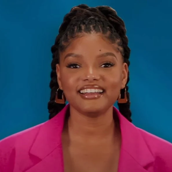 Halle Bailey souriant en veste rose pendant la promotion de The Little Mermaid en 2023