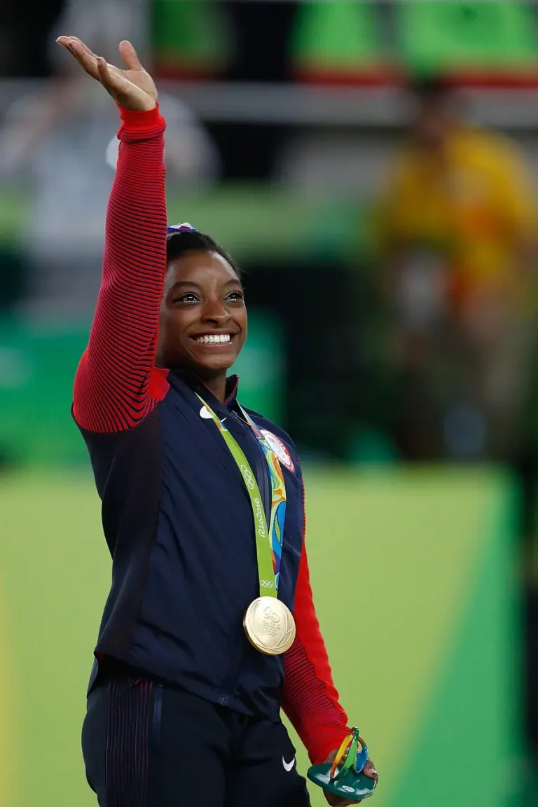 Simone Biles con una medaglia olimpica mentre saluta a Rio de Janeiro nel 2016