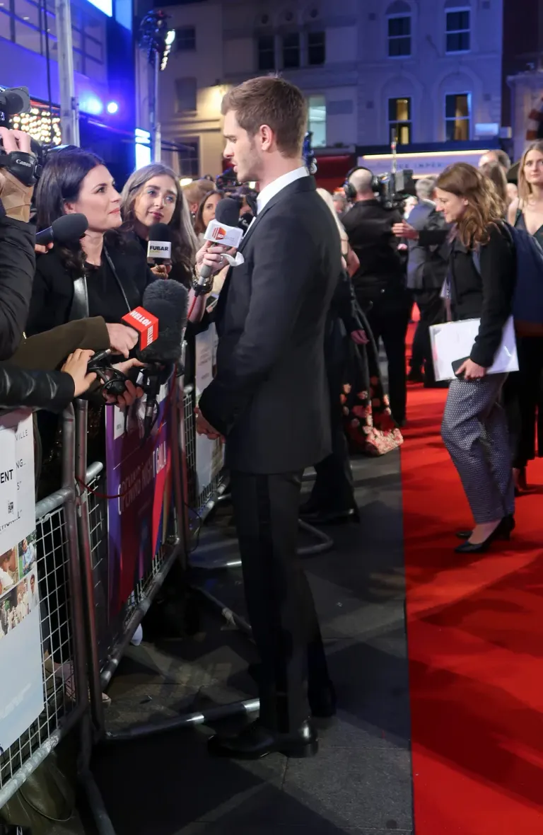 Fotografia a figura intera di profilo di Andrew Garfield mentre parla con i giornalisti alla prima di Breathe a Londra nell’ottobre 2017