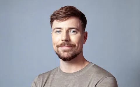 Portrait of MrBeast wearing a gray shirt against a pale blue background