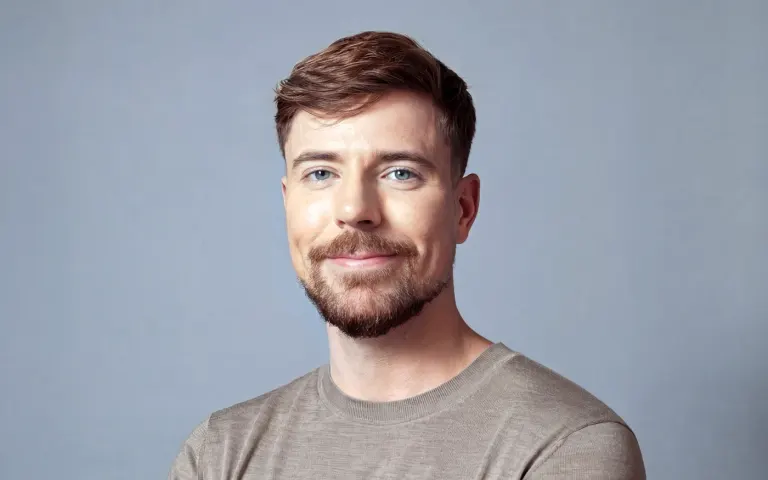 Portrait de MrBeast en haut gris sur fond bleu pâle