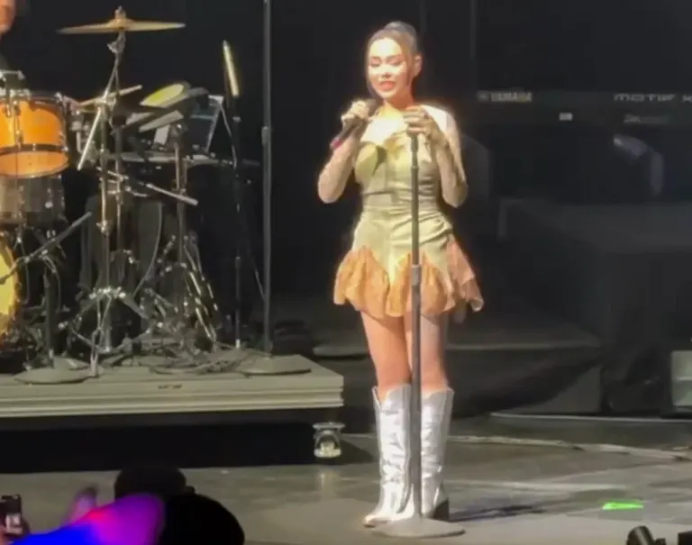 Bella Poarch sul palco con un microfono durante il Pink Aura Tour del 2024