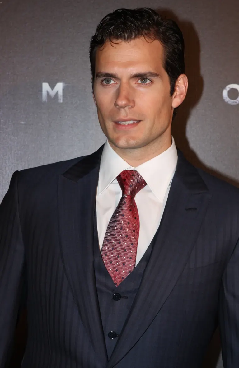 Henry Cavill in abito scuro e cravatta rossa alla prima di Man of Steel a Sydney nel giugno 2013